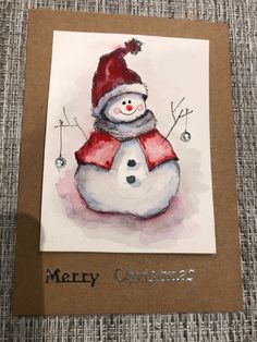 a card with a snowman wearing a red hat and scarf on it's head