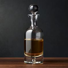 an empty glass bottle filled with liquid on top of a wooden table