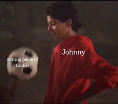 a young man holding a soccer ball with the words johnny written on it in front of him