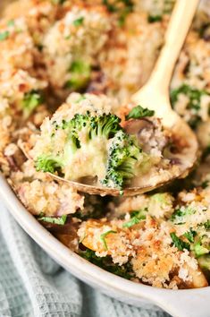 a casserole dish with broccoli, mushrooms and cheese on it is being held by a wooden spoon