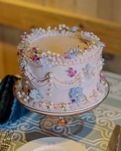 a three layer cake sitting on top of a table next to plates and silverware