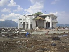 a large white building sitting on top of a dirt field