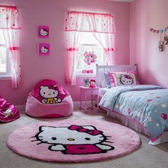 a bedroom decorated in pink and white with hello kitty rugs on the floor next to bed