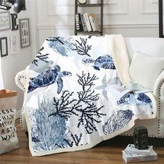 a living room with a white couch covered in a blue and white sea turtle blanket