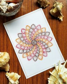 a card with an image of a flower on it next to seashells