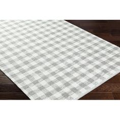 a white and grey checkered rug on a wooden floor