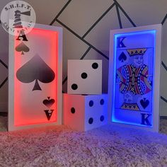 three lit up playing cards and dices on the floor in front of a wall