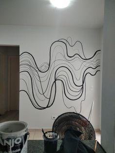 the wall is painted with black lines and white paint, while two buckets are next to it