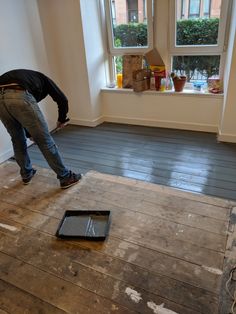 a man standing on top of a hard wood floor next to a tablet computer monitor