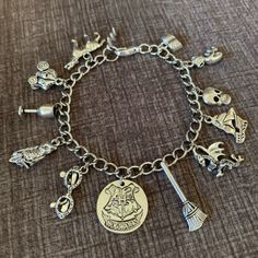 a harry potter charm bracelet with charms on the clasp and an image of hogwart's crest