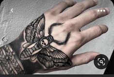 a person's hand with a tattoo on it and a moth on the wrist