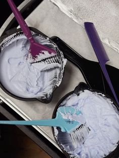 two toothbrushes sitting in tins on top of a table