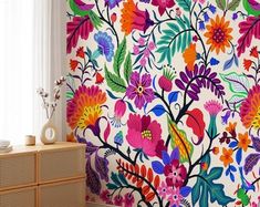 a colorful floral wallpaper in the corner of a room next to a dresser and window