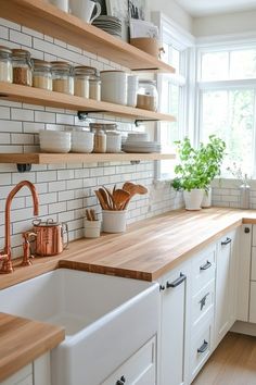 a kitchen with wooden counter tops and white subway backsplash, open shelving above the sink