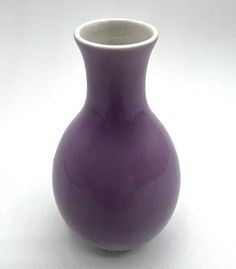 a purple vase sitting on top of a white table