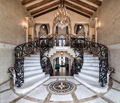 an ornate staircase with chandelier and marble floors