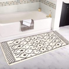 a bath tub sitting next to a white rug