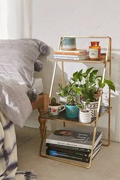 a bedroom with a bed, nightstand and plants