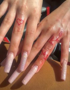 two hands with pink and white nail polish on them, one has a heart painted on it