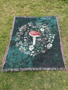 a rug with a mushroom on it in the grass