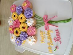 a birthday cake decorated with flowers on a tray