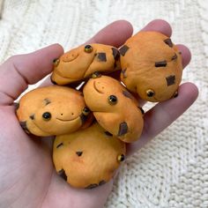 five small brown stuffed animals sitting on top of each other in someone's hand