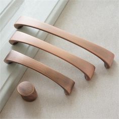 three wooden handles on the side of a window sill, one with a round knob