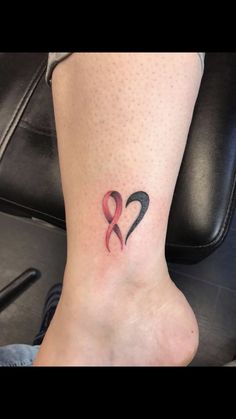 a tattoo on the foot of a woman with two hearts and an arrow in it