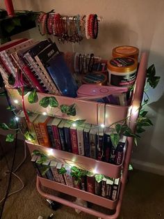 a pink cart filled with lots of books under a christmas tree covered in fairy lights