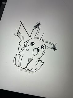 a drawing of a pikachu sitting on top of a piece of white paper