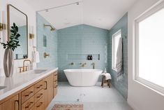 a bath room with a tub a sink and a mirror on the wall next to a window