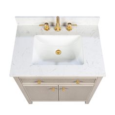 a white sink with gold faucet and marble counter top on an off - white cabinet