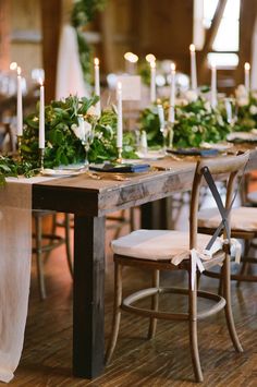 the table is set with candles and greenery