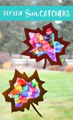 two paper fall leaves hanging from a window with grass and trees in the back ground