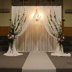 an aisle decorated with flowers and greenery at the end of a wedding ceremony in front of a brick wall