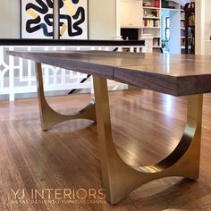 a large wooden table with metal legs in the middle of a wood floored room