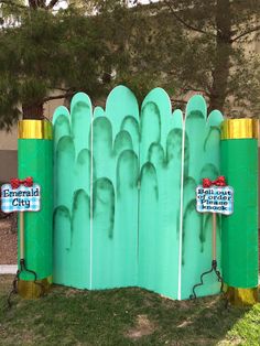 a fence made out of green plastic and gold posts with signs on them that say mermaid city