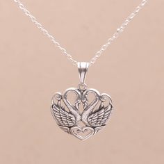 Crafted of sterling silver two swans join their necks to form a heart shape in the pendant of this necklace. Balinese artisan Dewa Arimbawa designs the necklace accentuated with a combination of finishes that captures the swans with a high level of detail.