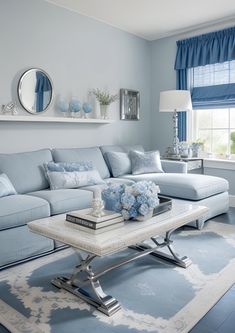 a living room filled with furniture and blue decor on top of a white coffee table