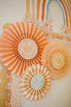 some paper flowers are sitting on a table with polka dots and rainbows in the background