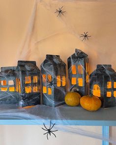 halloween decorations are displayed on a shelf in front of a wall with spider webs