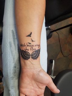 a person with a tattoo on their arm that says, with brave wings she flies