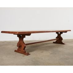 a large wooden bench sitting on top of a cement floor