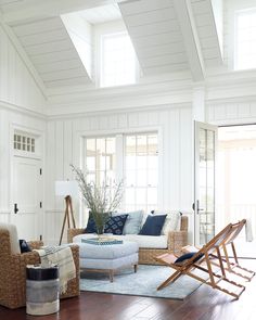 a living room with white walls and wood flooring on the wooden floor is furnished with wicker furniture