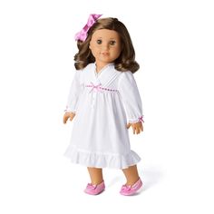 the doll is wearing a white dress and pink shoes