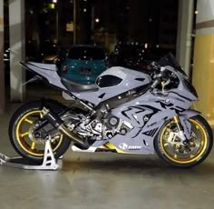 a silver motorcycle parked in front of a blue car