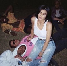 a group of people sitting around each other on the ground