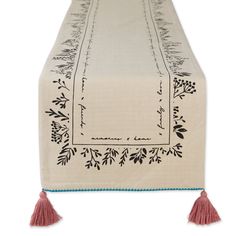 an embroidered table runner with tassels on it