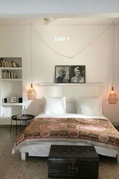 a bedroom with a bed, nightstands and pictures on the wall