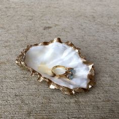 a ring sits in an oyster shell on the floor